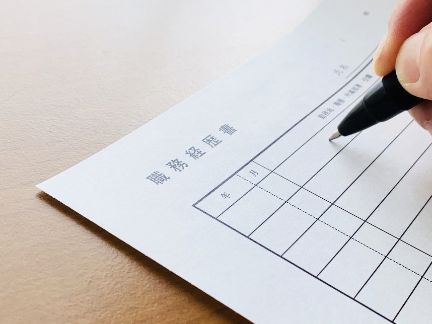 職務経歴書に書き込もうとする手