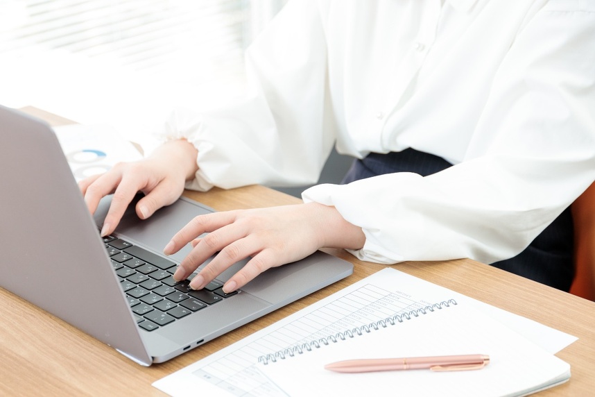 タイピングする女性の手とPC