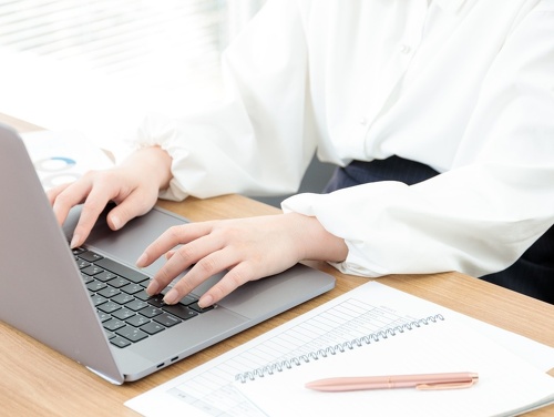 タイピングする女性の手とPC