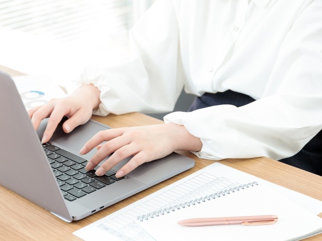 タイピングする女性の手とPC